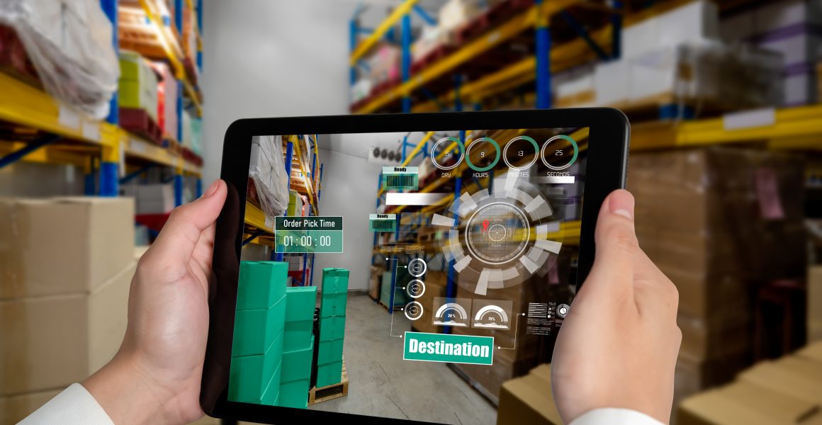 Warehouse manager using WMS software on a laptop to control inventory and logistics operations.
