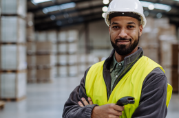 Organised SME warehouse with numbered shelves and employees performing inventory count.